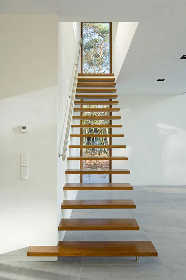 A seemingly floating staircase leads to the upper floor.