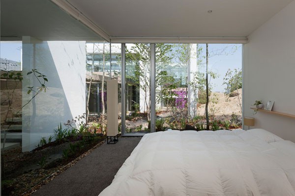 The bedroom - glass facades allow views of the garden.