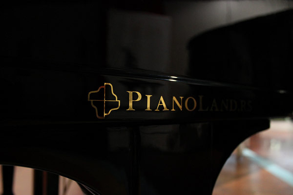 Golden logotype on the black piano.