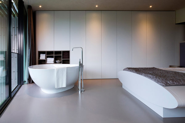A bedroom with integrated bathtub.
