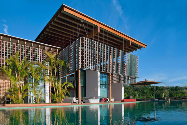 View from the pool to the house with the sun filtering wood lattice panel.