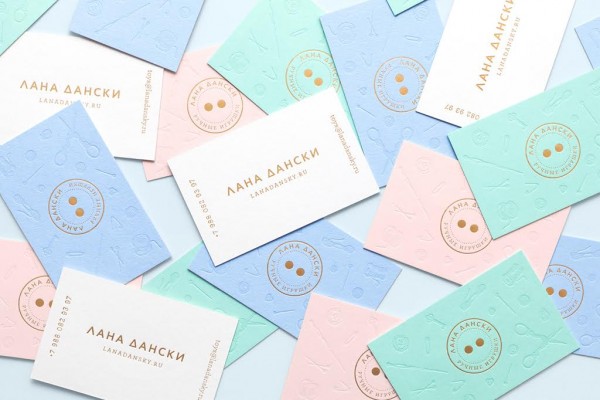 Business cards in different pastels and white plus golden letters.