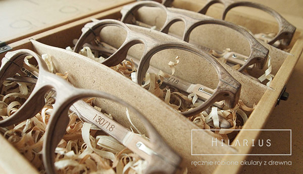Some wooden glasses embedded in wood chips in a box.