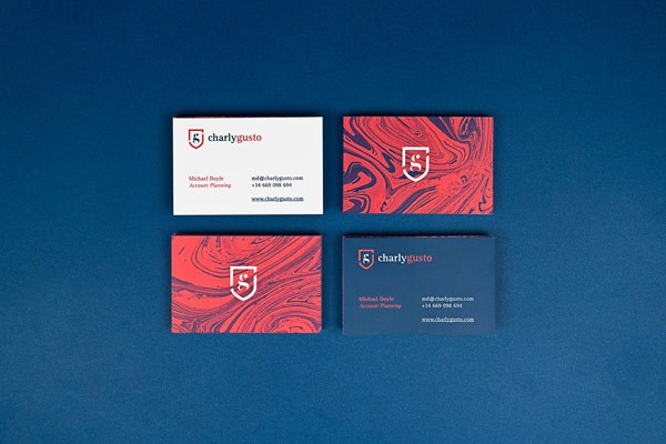 Business cards for Charly Gusto, a marketing professional with a British origin.