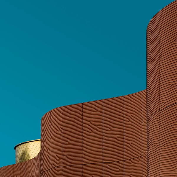 Undulating architecture in front of the blue sky.
