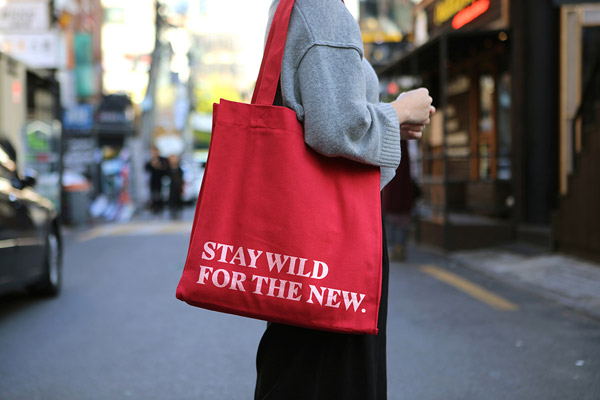 A red cloth bag with printed quote.