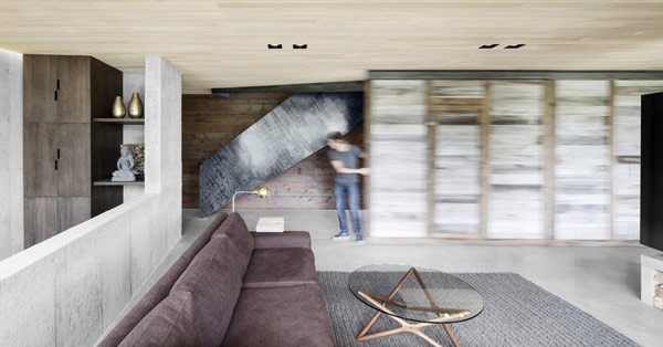 A movable wall separates the living room from the staircase.