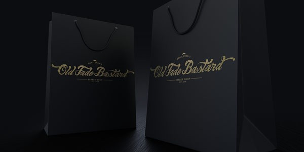 Black paper bags with golden logotype in old letters.