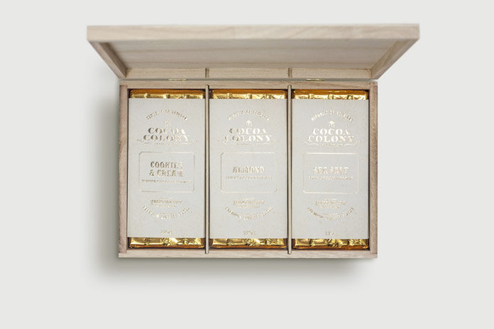 The wood box includes delicious chocolates wrapped in golden paper.
