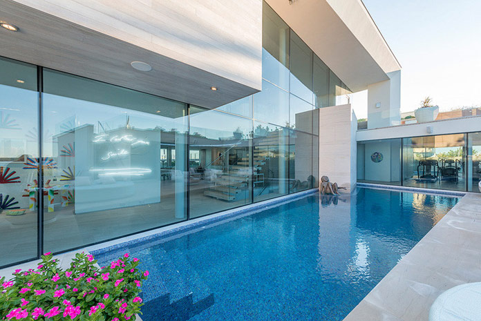 This pool is placed directly at the glass facade of the house.