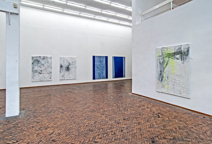 Numerous artworks by Koen Delaere at an exhibition.