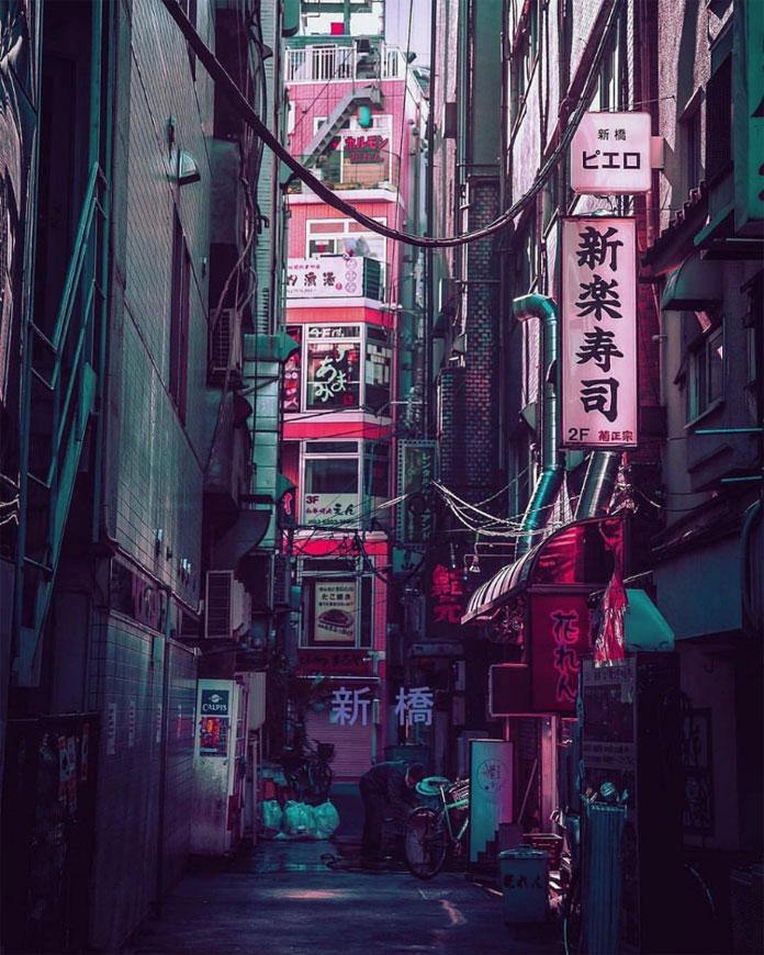 A narrow path surrounded by high houses and neon lights.