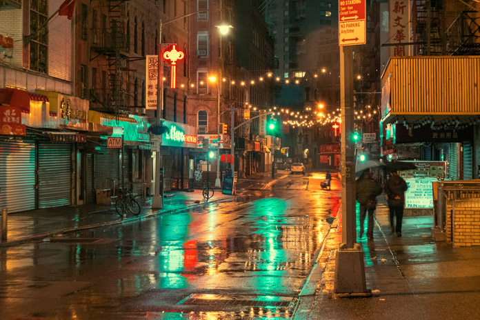 Traffic lights are reflected in the wet streets.