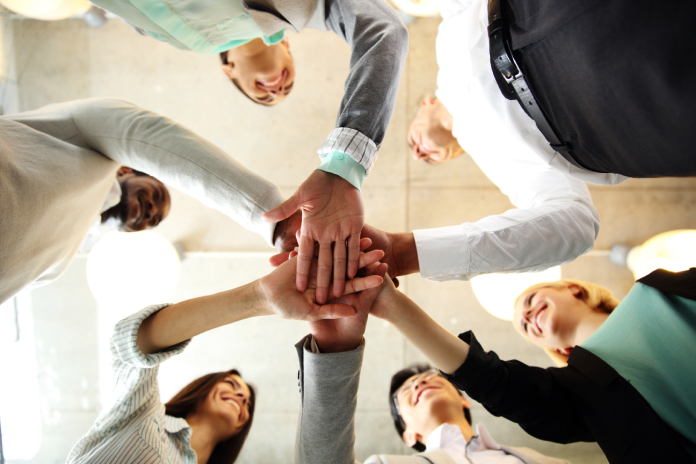 Business people teamwork in an office with hands together